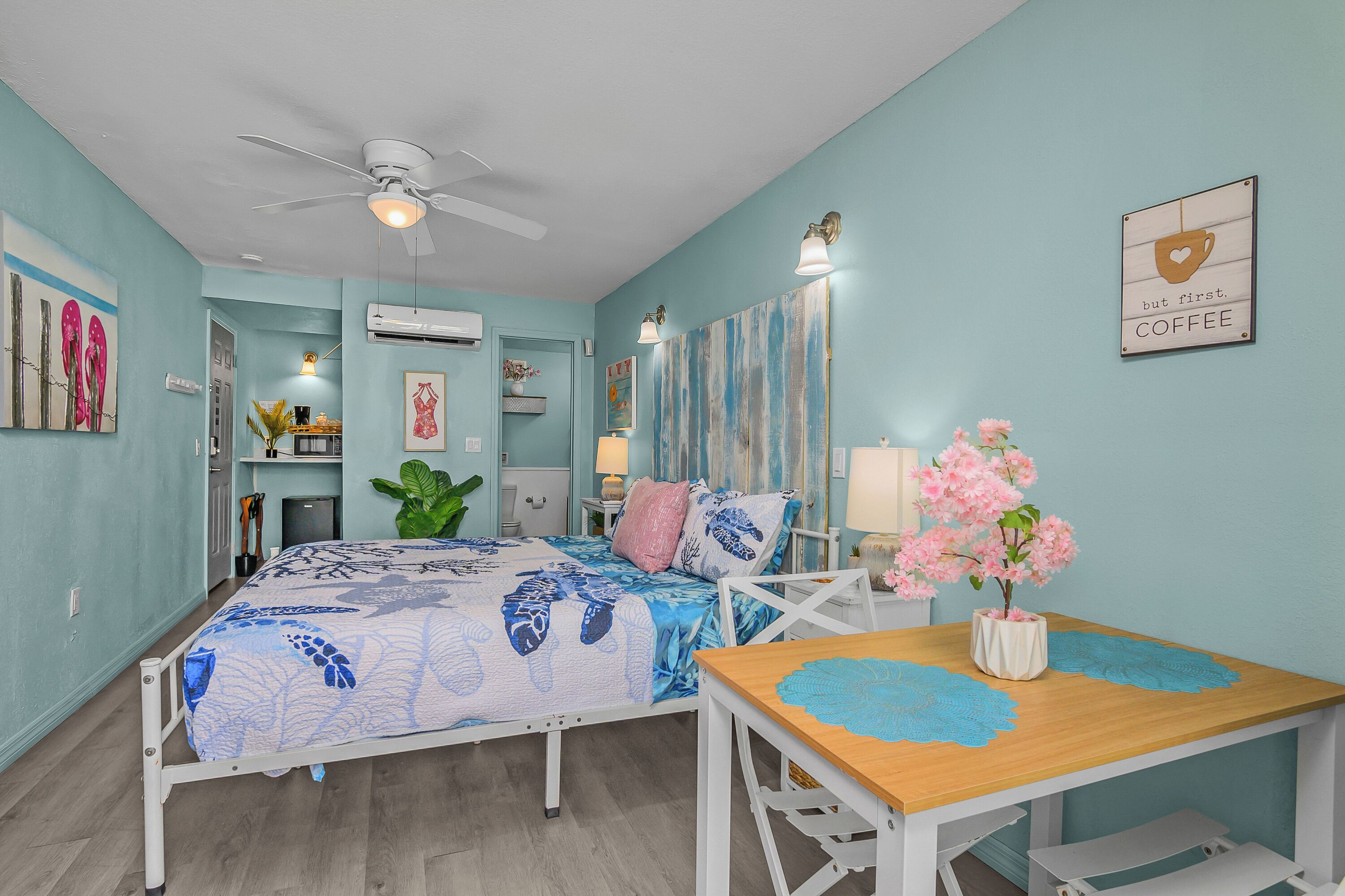 A bedroom with a bed, bedside table, and a wall-mounted air conditioner.