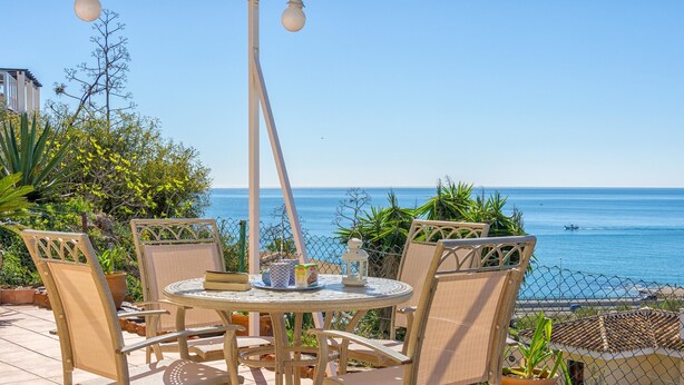 A patio with a round table and chairs, overlooking a clear blue sea. - Polarsol 2 (Mijas)