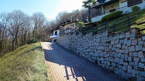A paved pathway leading to a stone wall with a house on the right. - Thommy apartment in Stresa with  lake view (Stresa)