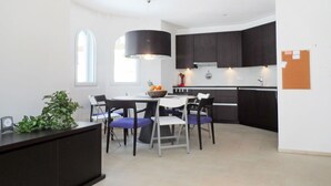 Une cuisine moderne avec des meubles de couleur sombre, un îlot central et un coin repas avec des chaises.