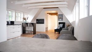 A modern loft apartment with a dining area, kitchen, and living space. - Hotel City (Holstebro)