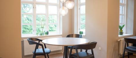 Un coin repas avec une table ronde, deux chaises et des luminaires suspendus.