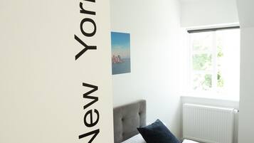 Habitación de hotel con dos camas y vista a la ciudad, con una puerta que indica '21 New York'.