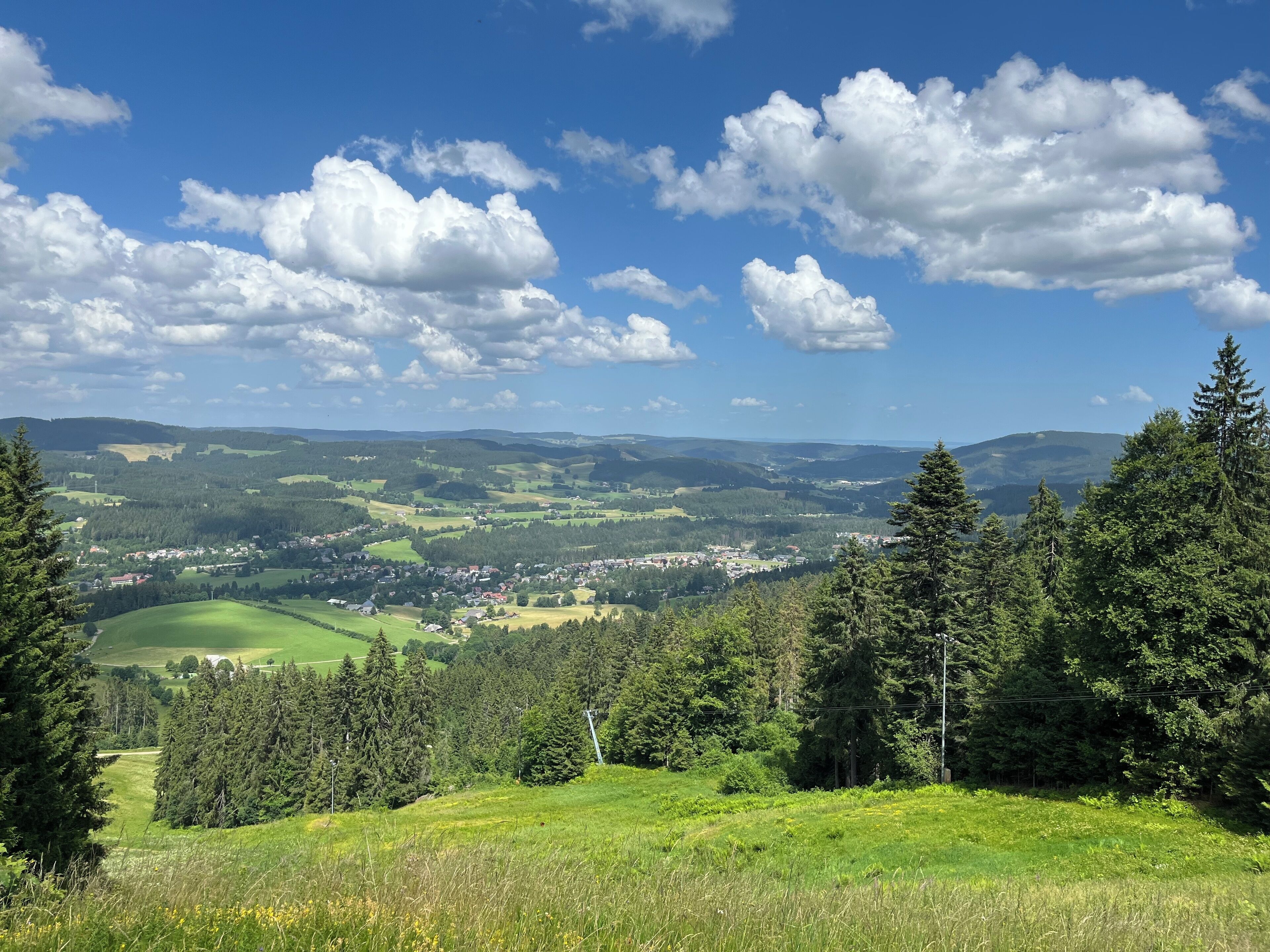Une vue panoramique d’un paysage montagneux, avec une ville nichée au fond de la vallée.
