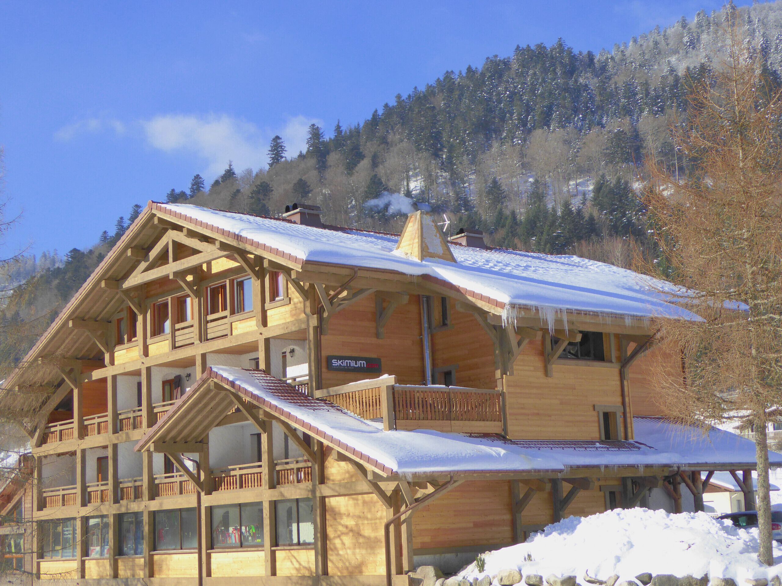 A wooden chalet with multiple balconies and a ski lift.