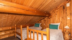A wooden cabin with two bunk beds, a wooden ceiling, and a small bedside table with a lamp. - Magnifique Chalet rondins à La Bresse, tout confort, wifi, proche pistes, calme (La Bresse)