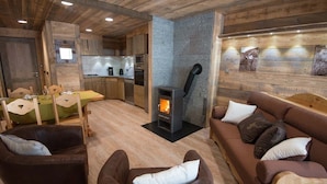 Een gezellig interieur met een open haard, houten meubels en een keukenhoek.