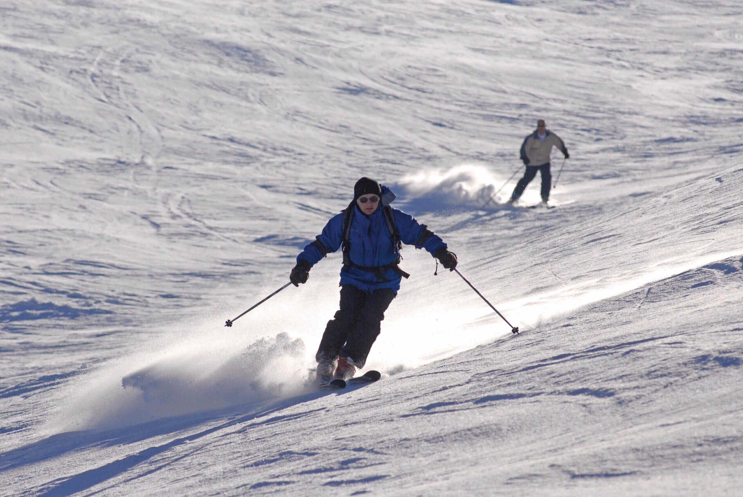 Iemand skiënd een besneeuwde helling af.
