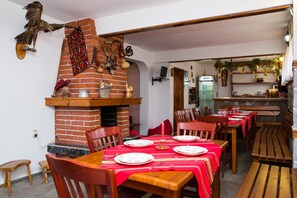 Un espace repas avec des murs en briques, des tables et des chaises en bois.