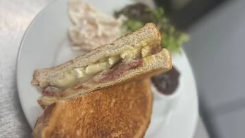 A grilled sandwich on a plate with a side salad.