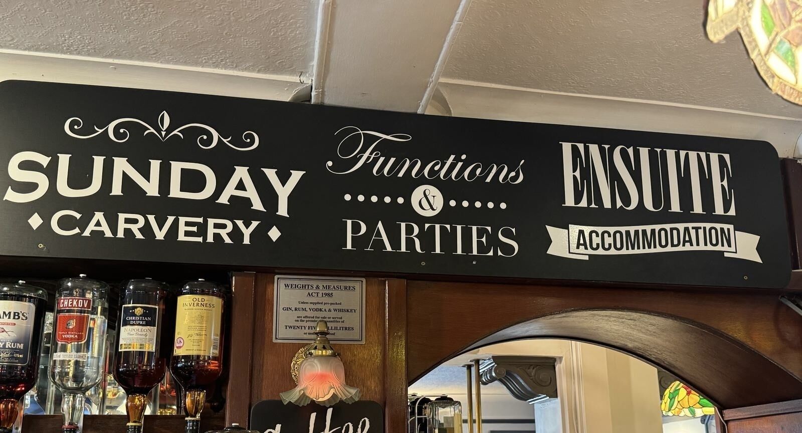 A bar area with a sign indicating services like Sunday Carvery, Functions & Parties, and Accommodation.