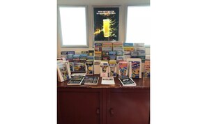 A display of books and magazines on a wooden counter with a window in the background. - The Kings Arms (North Walsham)