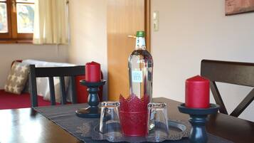 Een eettafel met een waterfles, rode kaarsen en zout- en peperstel op een placemat.