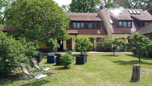 A two-story house with a garden, outdoor seating, and a well-maintained lawn. - FRITZ Aparthotel Potsdam (Potsdam)