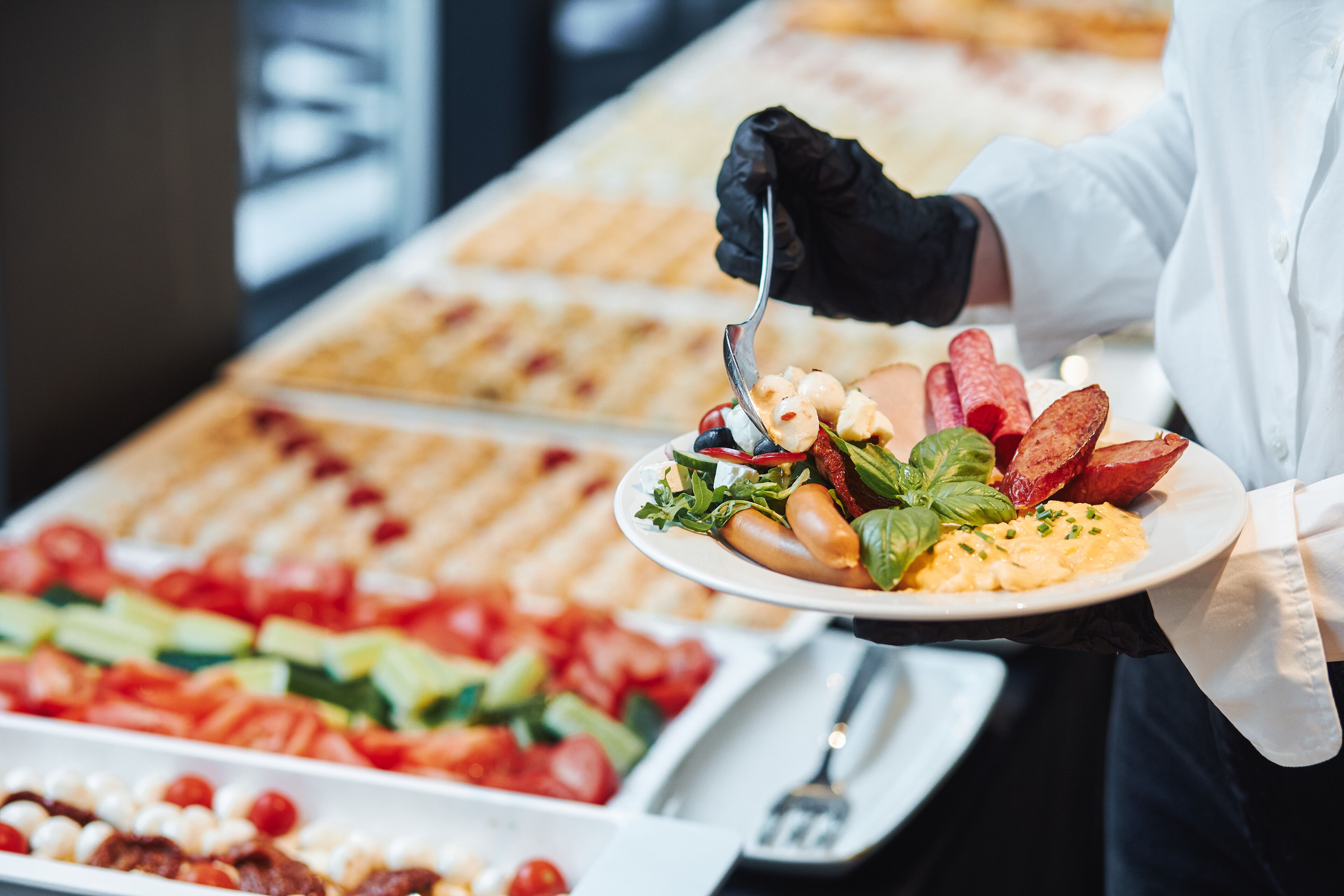 Un bufé con diversas opciones de comida, incluyendo ensaladas, carnes y mariscos.