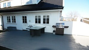 A covered patio with a grill and table. - Solferie Holiday Home - Korsvikkilen (Kristiansand)
