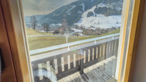 A view from a window overlooking a snow-covered mountain landscape with a clear sky.