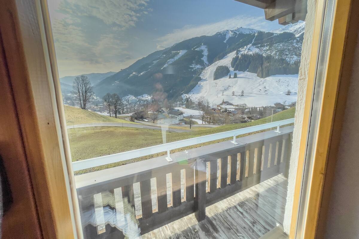 A view from a window overlooking a snow-covered mountain landscape with a clear sky.