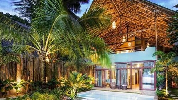 A modern resort with a pool, tropical vegetation, and a thatched-roof structure. - Buko Beach Resort - Adults Only (El Nido)
