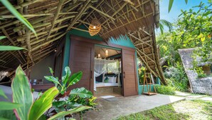 A thatched-roof structure with a bed and a ladder, surrounded by greenery. - Buko Beach Resort - Adults Only (El Nido)