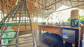 A bamboo-framed ceiling, a wooden bench, and a small table with a power outlet.