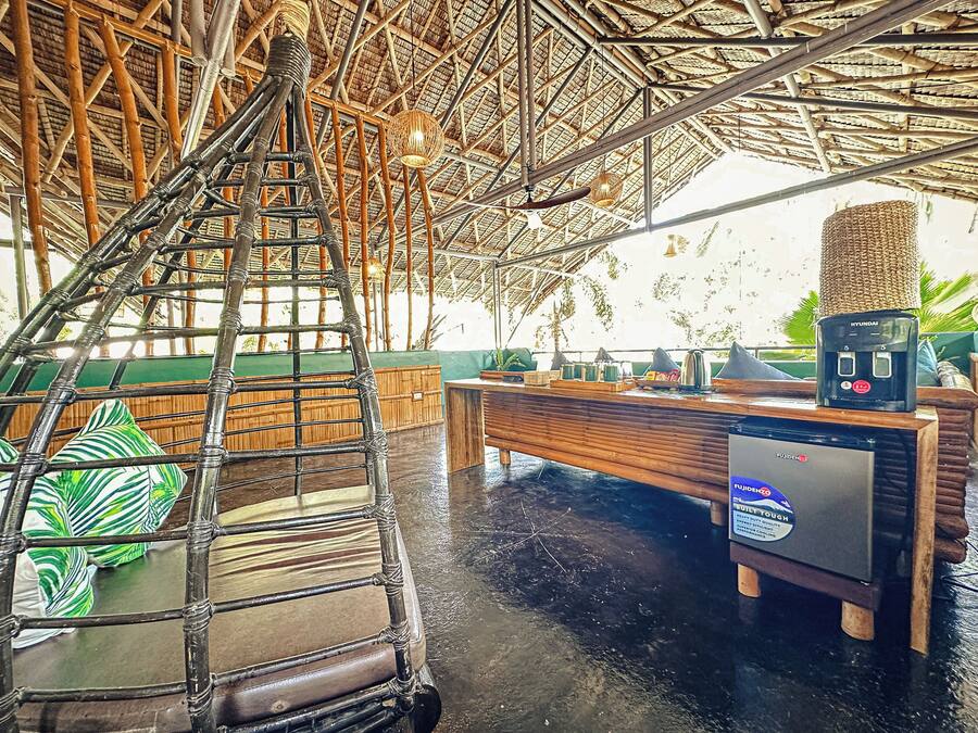 A bamboo-framed ceiling, a wooden bench, and a small table with a power outlet.