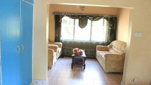 A living room with two sofas, a coffee table, and a window with curtains.