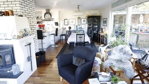 A modern living room with a fireplace, a dining area, and a kitchen. - Solferie Holiday Home Vardåsveien (Kristiansand)