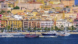 A coastal cityscape with historic buildings, a marina with boats, and a clear blue sky. - Lumiere Rooms - Eja Sardinia (Cagliari)