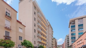 A multi-story building with balconies and a clear sky. - Lumiere Rooms - Eja Sardinia (Cagliari)