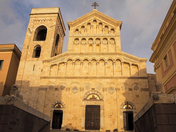 A historic building with a prominent bell tower and a central entrance with ornate decorations.