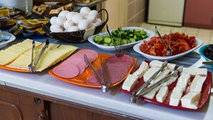 A buffet table with various food items including sliced meats, cheeses, eggs, and vegetables. - Yellow Rose Pansiyon (Çanakkale)