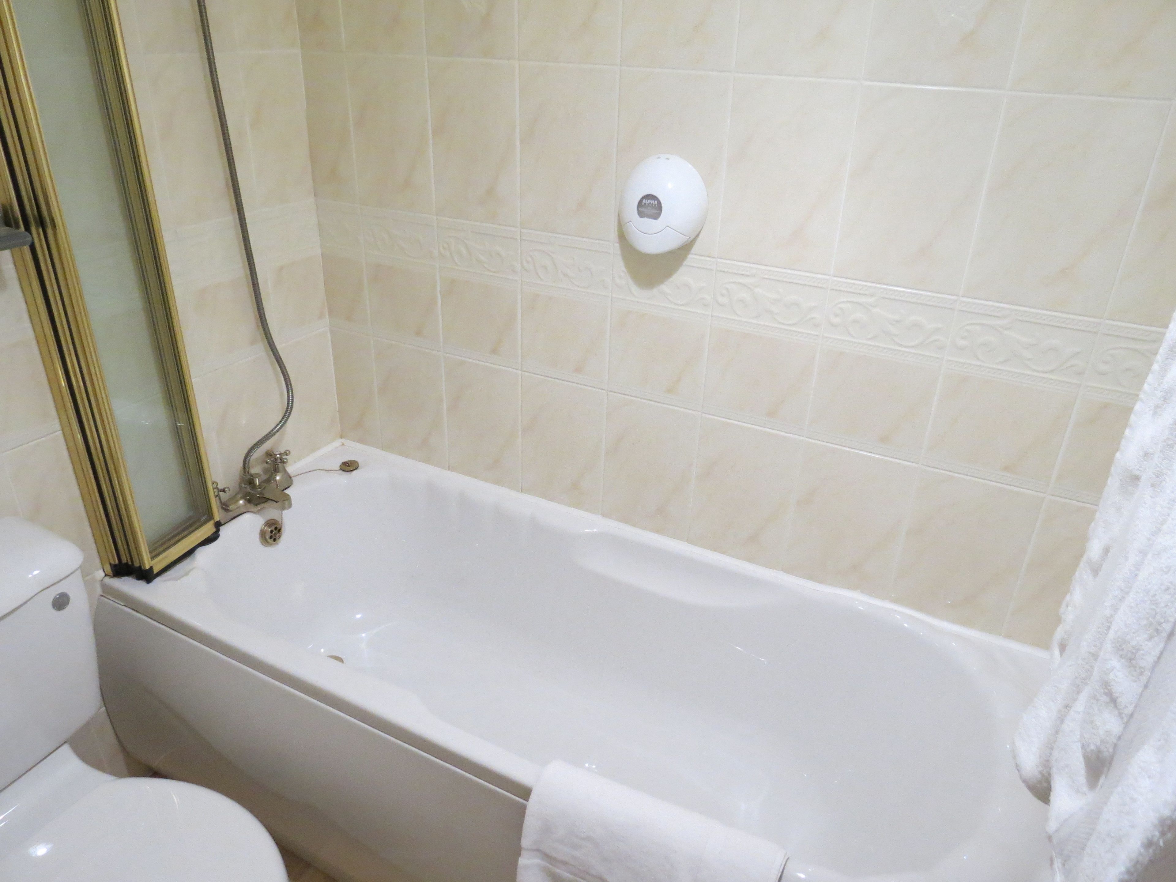 Un bagno con vasca, WC e asciugatore di mani.