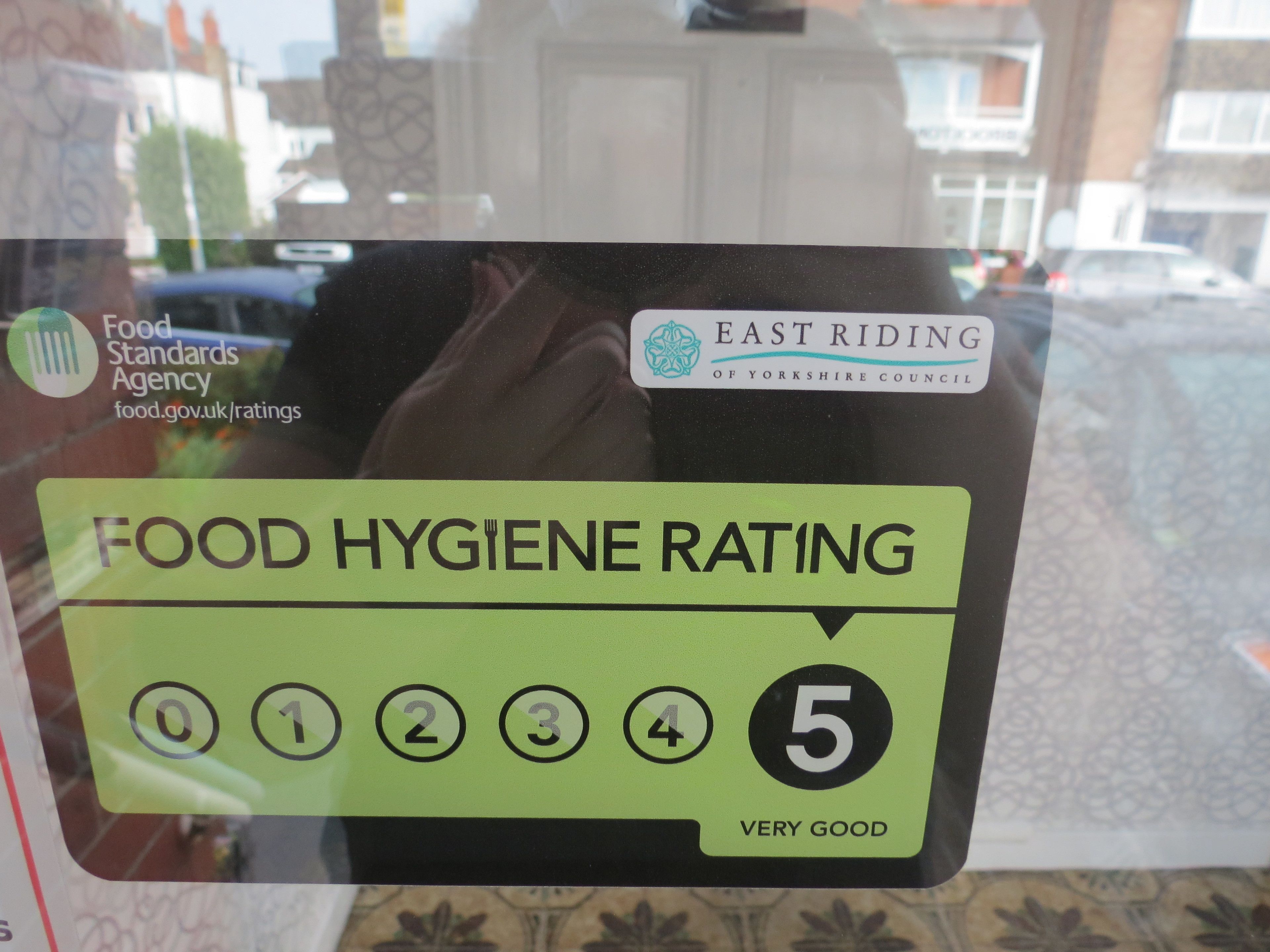 Un panneau indiquant le niveau d’hygiène alimentaire, avec une note de 5 étoiles et le texte « TRÈS BIEN », dans le district de l’East Riding of Yorkshire.