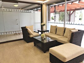 Una sala de estar moderna con un sofá, sillones y una mesa de centro.