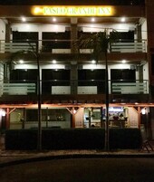 Un edificio de varios pisos con un cartel llamativo que dice "PASEO GRANDE INN".