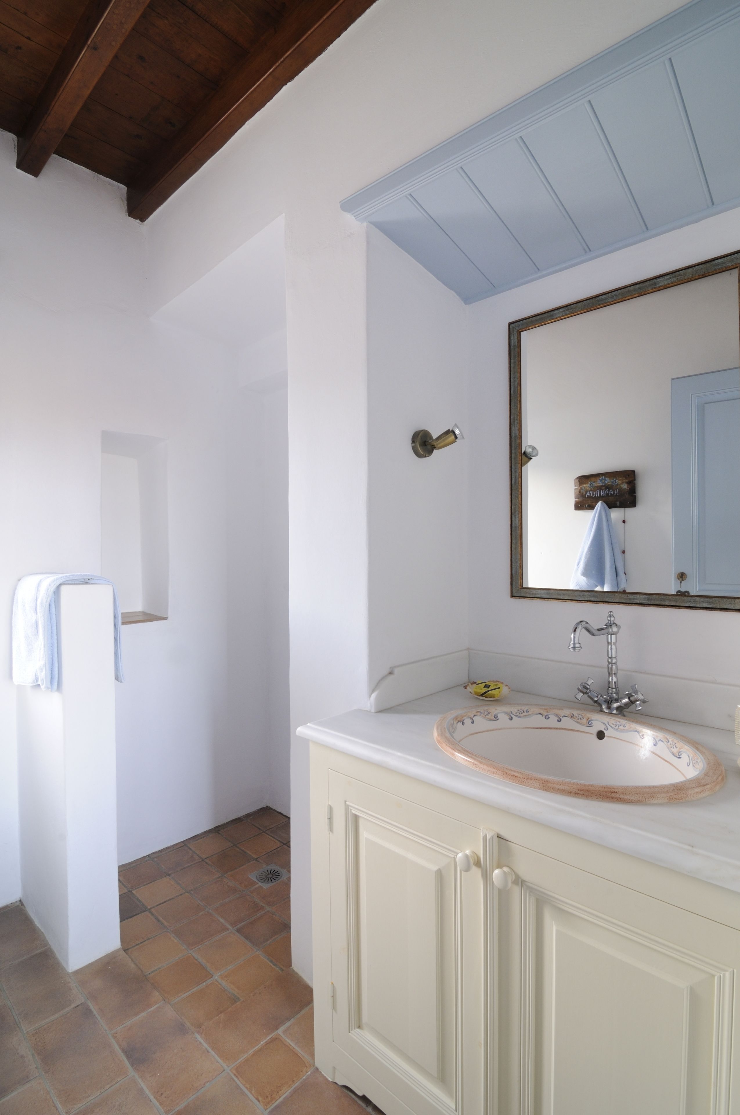 A bathroom with a white sink, a mirror, and a shower.