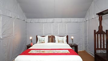 A bedroom with a bed, nightstands, and a wooden chair.