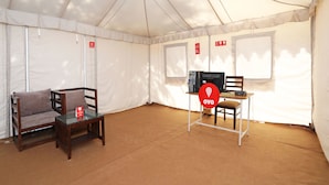 Ett tält med en receptionsdisk, en dator och två stolar.