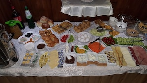 A buffet table with various food items, condiments, and beverages. - Hotel Danisimo (Tbilisi)