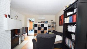 Een woonkamer met een open haard, een boekenkast en een televisie.