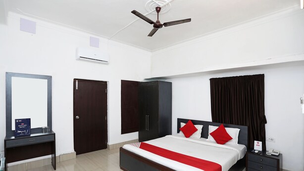 A bedroom with a bed, bedside table, wardrobe, and a ceiling fan. - OYO 11569 Jalan Lake View (Kolkata)
