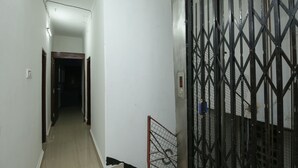 A narrow hallway with a metal gate and a digital elevator control panel. - OYO 11569 Jalan Lake View (Kolkata)