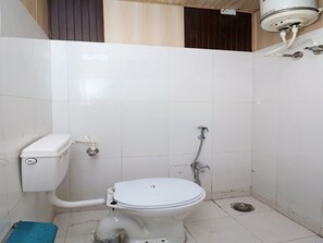 A small, basic bathroom with a toilet, a shower, and a blue step. - OYO 13234 Hotel Mahak (Lucknow)