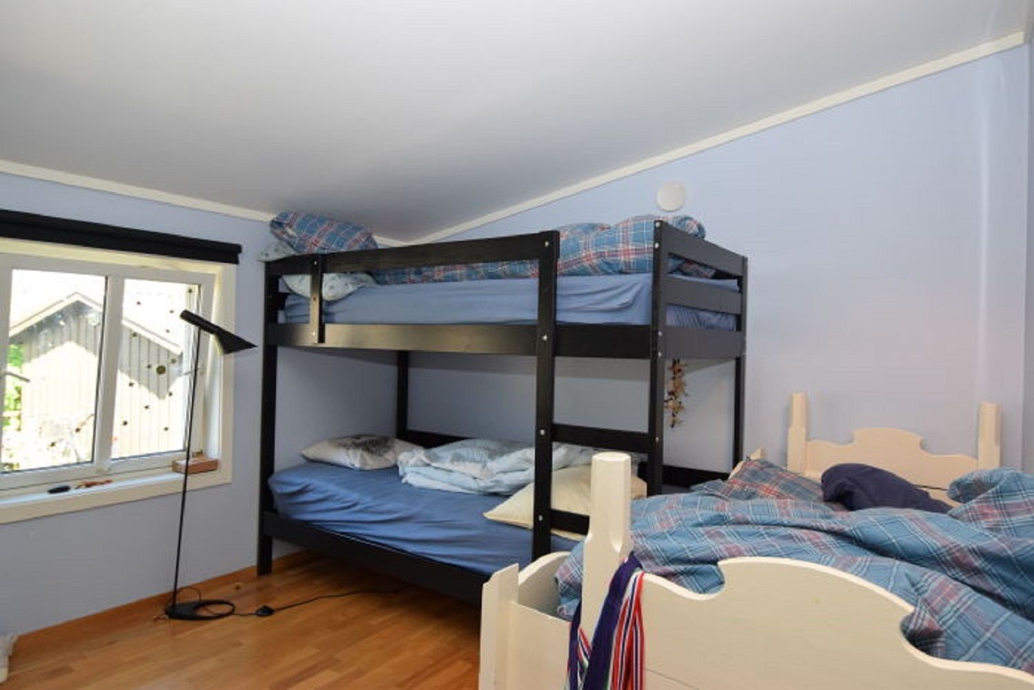 Habitación con literas, una ventana, un escritorio y una lámpara.