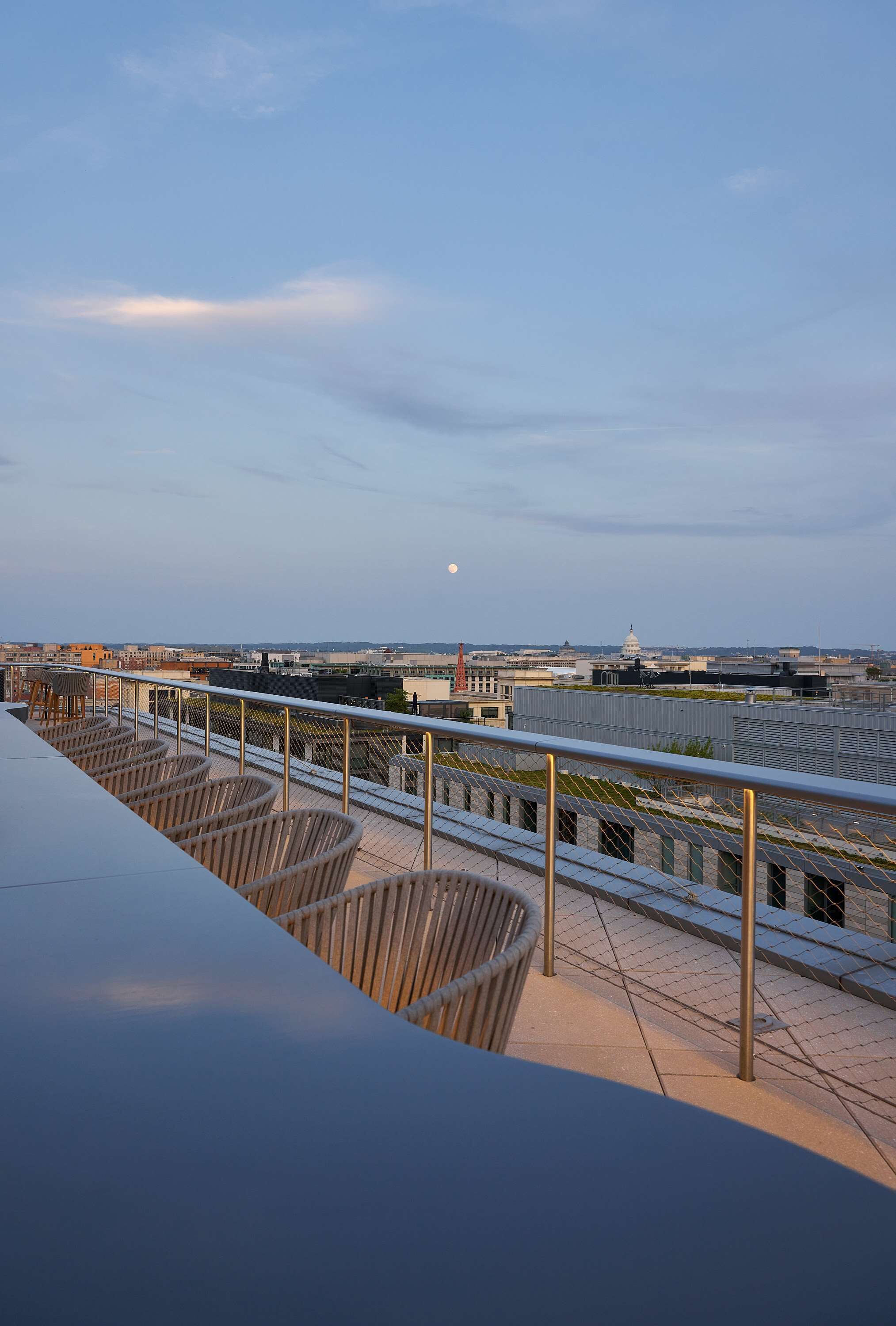 A rooftop terrace with a view of a cityscape, including a prominent building with a dome.