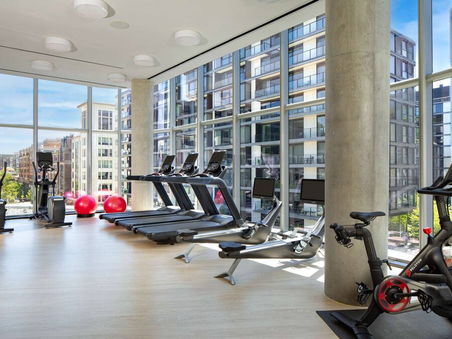 A modern gym with treadmills, elliptical machines, and stationary bikes.