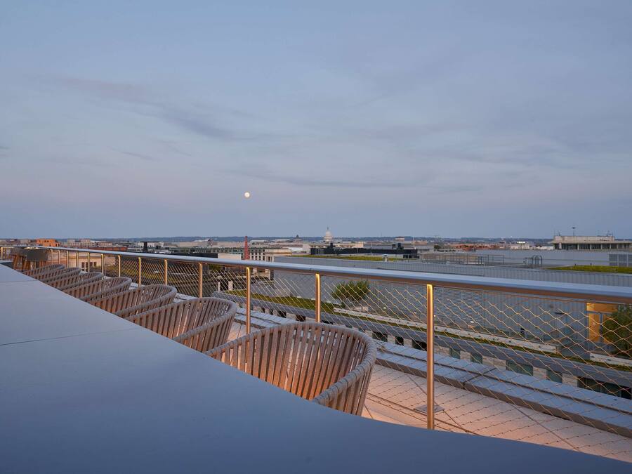A rooftop terrace with seating and a view of the airport and cityscape.
