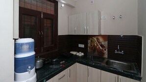 Cozinha com dispensador de água, fogão e pia.