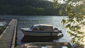 A dock with two boats moored at a lakeside. - Solferie Holiday Apartment Østerveien (Kristiansand)